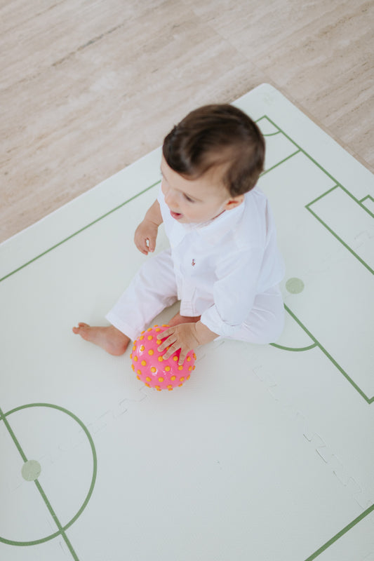 Criança brincando no tapetinho Soccer Tini Tiny — seguro, atóxico e hipoalergênico