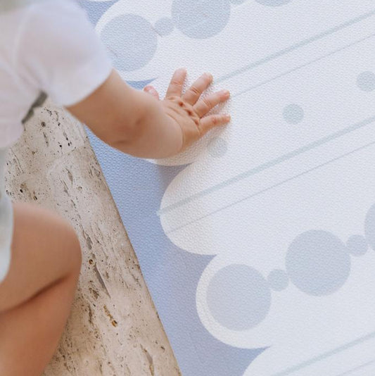 Criança brincando no tapetinho Blue Bubbles Stripes Tini Tiny — seguro, atóxico e hipoalergênico