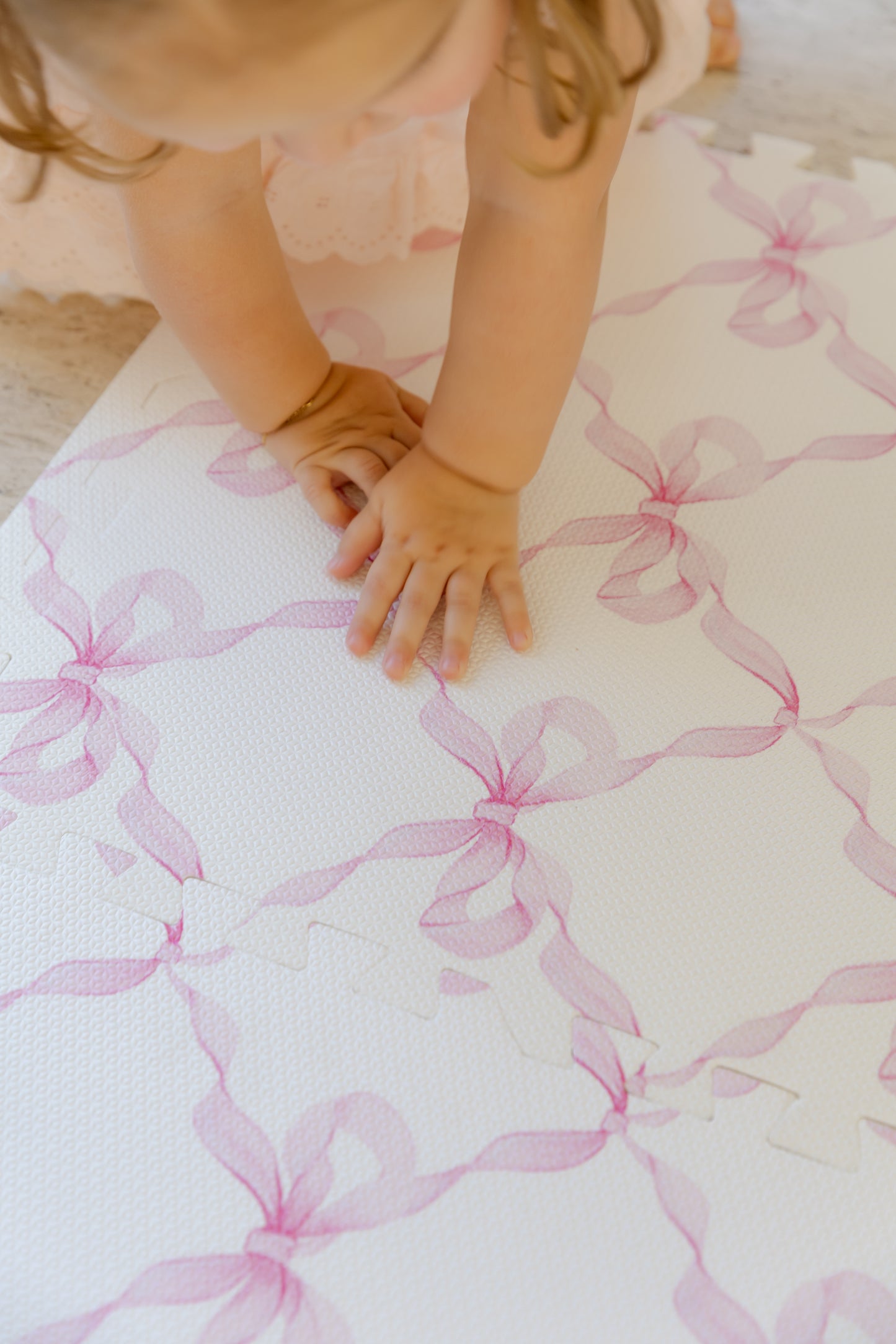 Criança brincando no tapetinho Laços Florença Rosa Tini Tiny — seguro, atóxico e hipoalergênico