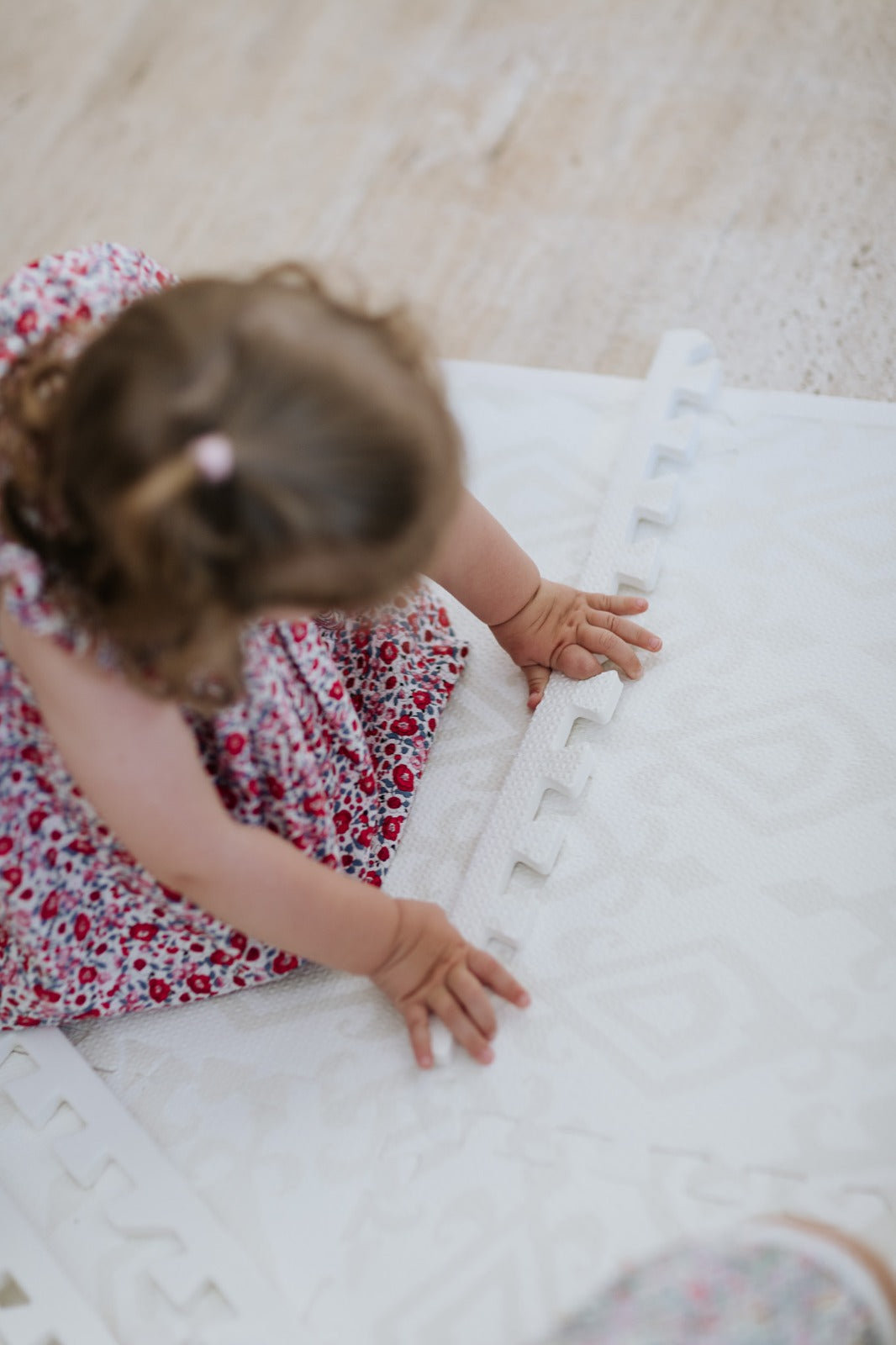 Criança brincando no tapetinho Ikat Tini Tiny — seguro, atóxico e hipoalergênico