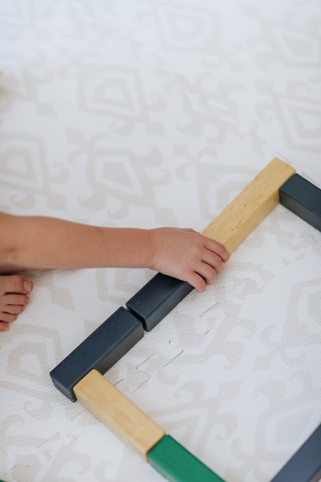 Criança brincando no tapetinho Ikat Tini Tiny — seguro, atóxico e hipoalergênico