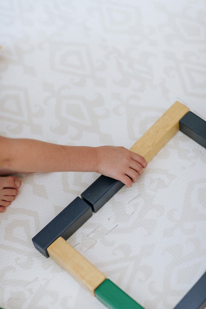 Criança brincando no tapetinho Ikat Tini Tiny — seguro, atóxico e hipoalergênico