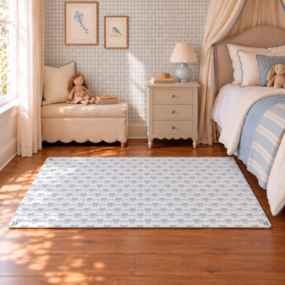 Tapete infantil de EVA Tiny Bows azul montado em quarto infantil com papel de parede xadrez, cama e criado-mudo