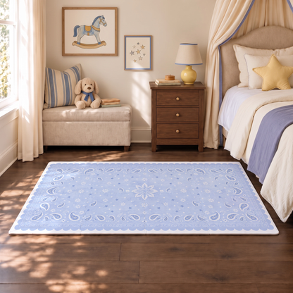 Tapete infantil de EVA Bandana azul no quarto, ao lado da cama com manta azul e almofada de estrela, banco com cachorrinho de pelúcia e quadro de cavalinho