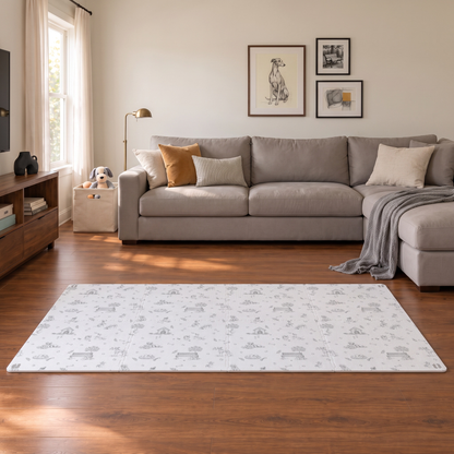 Tapete infantil de EVA Toile de Jouy Dogs cinza na sala, com sofá de canto cinza, manta cinza e luminária de chão