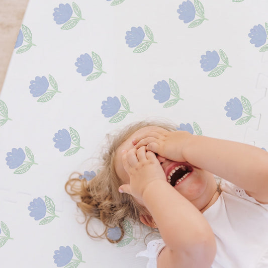 Criança brincando no tapetinho Flora Azul Tini Tiny — seguro, atóxico e hipoalergênico