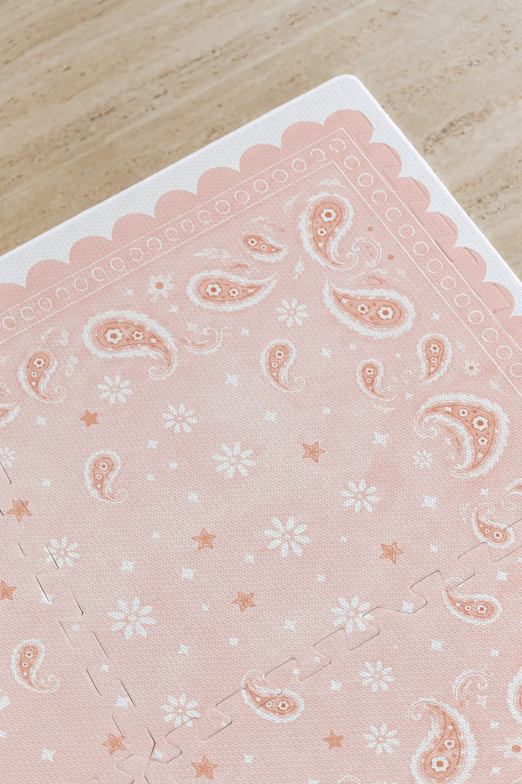 Detalhe do canto do tapete infantil de EVA Bandana rosa, com paisley, florzinhas, estrelinhas e borda ondulada