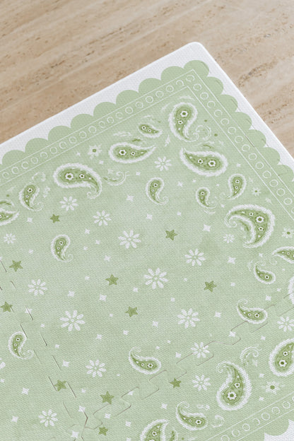 Detalhe do canto do tapete infantil de EVA Bandana verde, com paisley, florzinhas, estrelinhas e borda ondulada