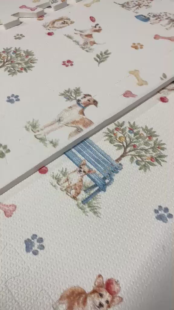 Vídeo de perto das placas do tapetinho Toile de Jouy Dogs multicolorido, com cachorrinhos em aquarela, banco azul, arvorezinhas, ossinhos e patinhas coloridas