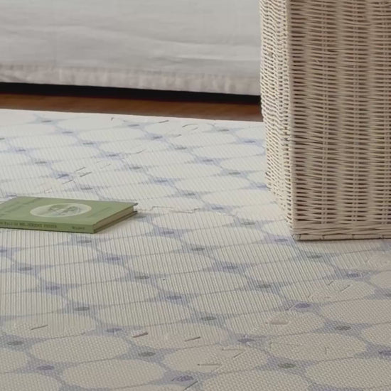 Vídeo de um adulto andando sobre o tapetinho Flower Power azul montado, com cachorrinho de pelúcia de balanço ao fundo