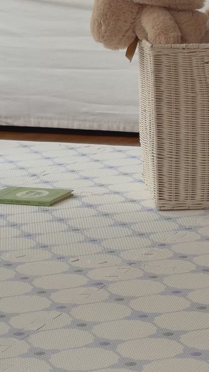 Vídeo de um adulto andando sobre o tapetinho Flower Power azul montado, com cachorrinho de pelúcia de balanço ao fundo