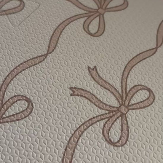 Vídeo de perto do tapetinho Tiny Bows rosa montado, com as fileiras de lacinhos ligados pela fita fina